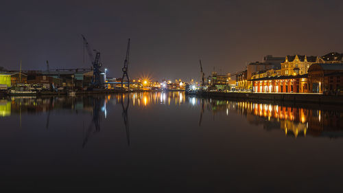 Reflection of illuminated buildings in lake against sky