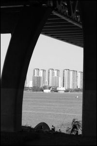 View of bridge over sea against buildings