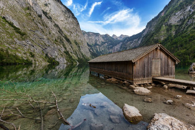 Houses by lake and mountains against sky