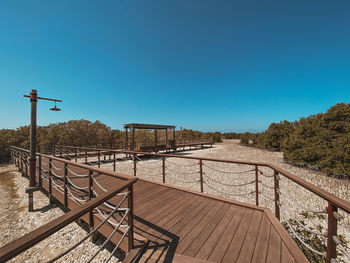 Empty railing against clear blue sky