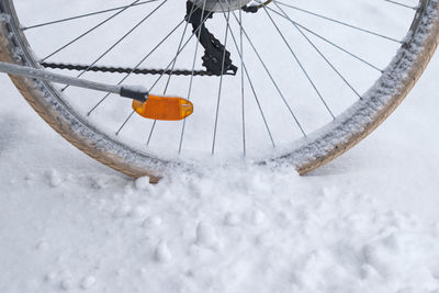 Close-up of snow covered bicycle on field