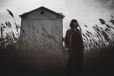 Woman standing on field against sky