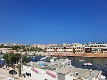 High angle view of marina and buildings against blue sky