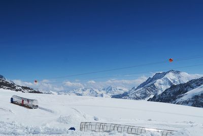 Scenic view of snowcapped mountains against blue sky