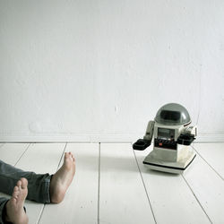 Low section of man on floor against white wall