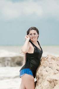 Portrait of beautiful young woman standing on beach
