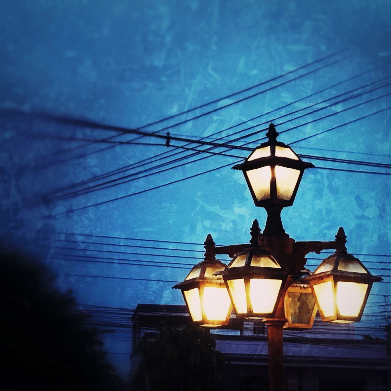 LOW ANGLE VIEW OF ILLUMINATED STREET LIGHT AT DUSK