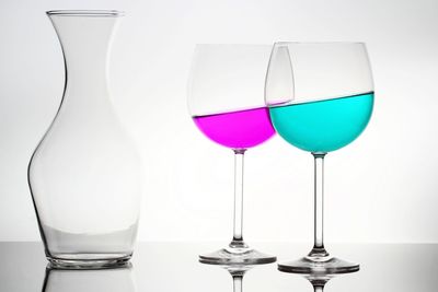 Close-up of drinks in glass on table against white background