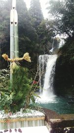 Scenic view of waterfall against trees