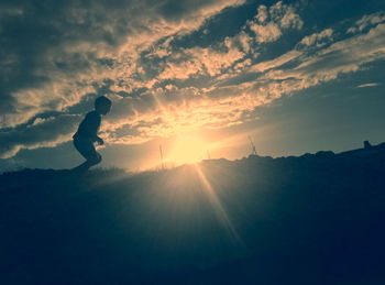 Silhouette woman against sky during sunset