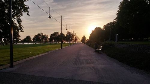 Road against cloudy sky at sunset