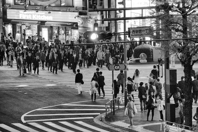 Crowd crossing road in city at night