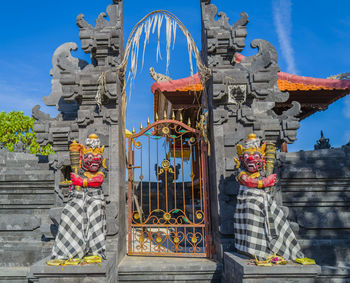 Statue against temple building against sky