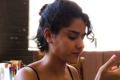 Portrait of young woman using mobile phone at home