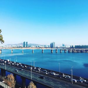 Bridge over sea against clear blue sky