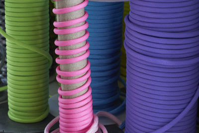 Colorful ropes rolled up of poles in warehouse