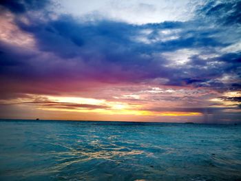 Scenic view of sea against dramatic sky during sunset