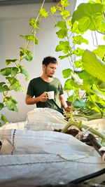 Young man looking away while sitting outdoors