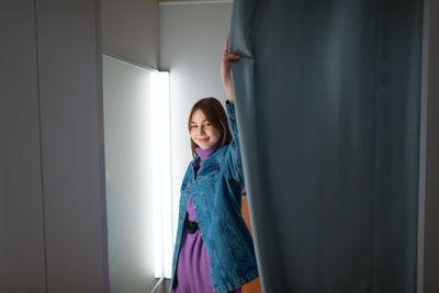 Smiling girl standing against door