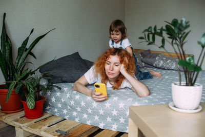 Young mother and child take photo together at home, have fun