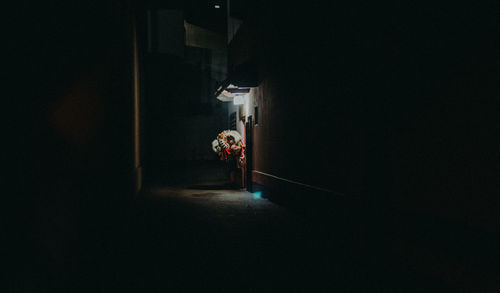 Rear view of woman walking in illuminated building