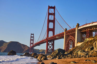 Low angle view of suspension bridge against sky