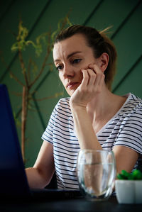 Woman working remotely at home office with laptop