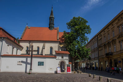 Street amidst buildings against blue sky