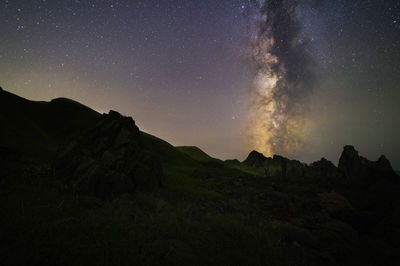 Scenic view of mountains against sky at night