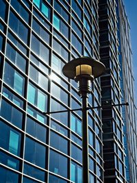 Low angle view of illuminated street light against building
