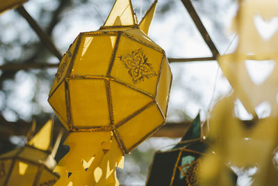 Low angle view of yellow decoration hanging against sky