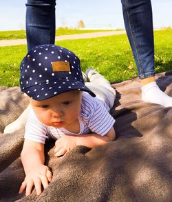 Close-up of cute baby boy lying on picnic blanket