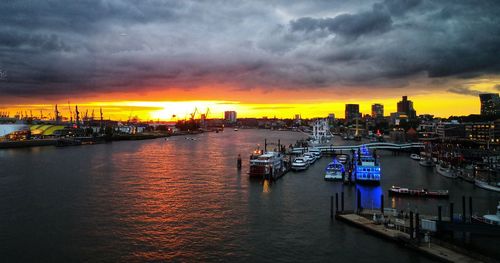 Scenic view of river against dramatic sky during sunset