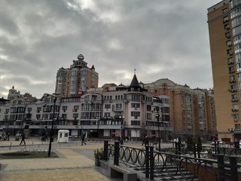 Buildings in city against cloudy sky