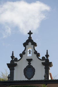 Low angle view of weather vane against sky