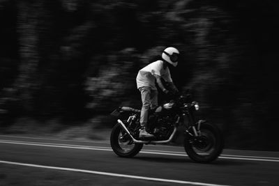 Man riding motor scooter on road