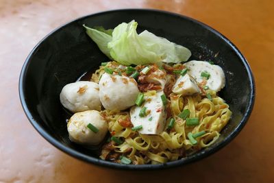 Close-up of fish ball with noodles served on table