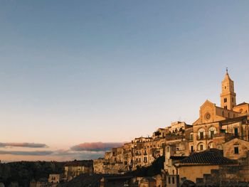 Buildings in city against clear sky