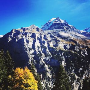 Scenic view of snowcapped mountains against clear blue sky