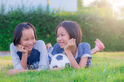 Portrait of happy girl lying on grassy field