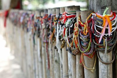 Close-up of colorful strings tied on wooden posts