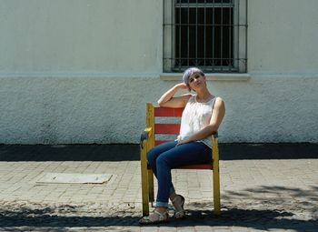 Full length of young woman sitting on bench