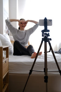 Rear view of woman holding camera
