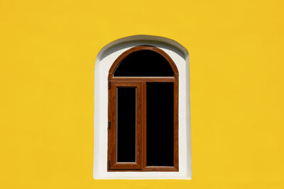 One arch window on yellow wall of old house. empty place for text. close-up.