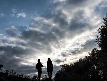 Rear view of silhouette women standing against sky