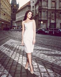 Full length portrait of beautiful woman standing on street in city