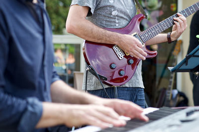 Midsection of man playing guitar