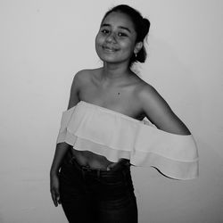 Portrait of smiling young woman against white background