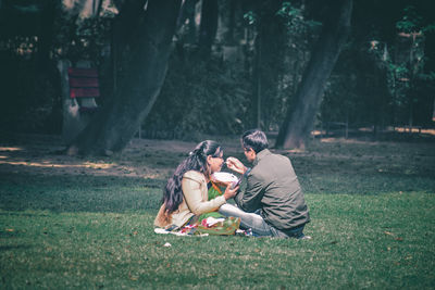 Rear view of woman sitting on field