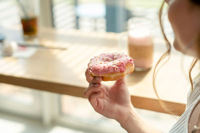 Midsection of woman holding donut